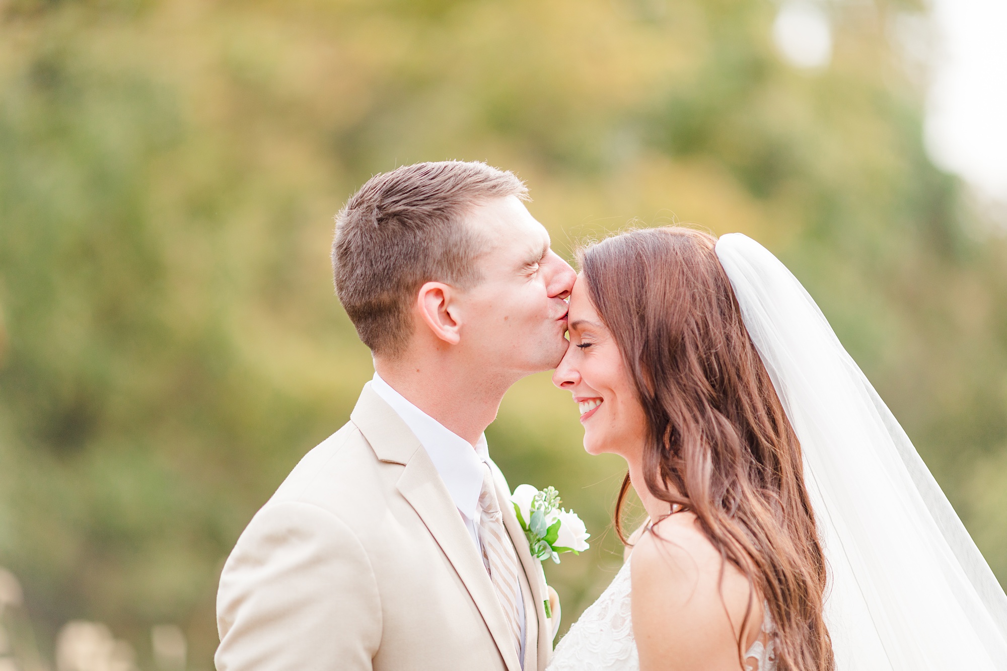 groom kisses bride's forehead during first look in Illinois