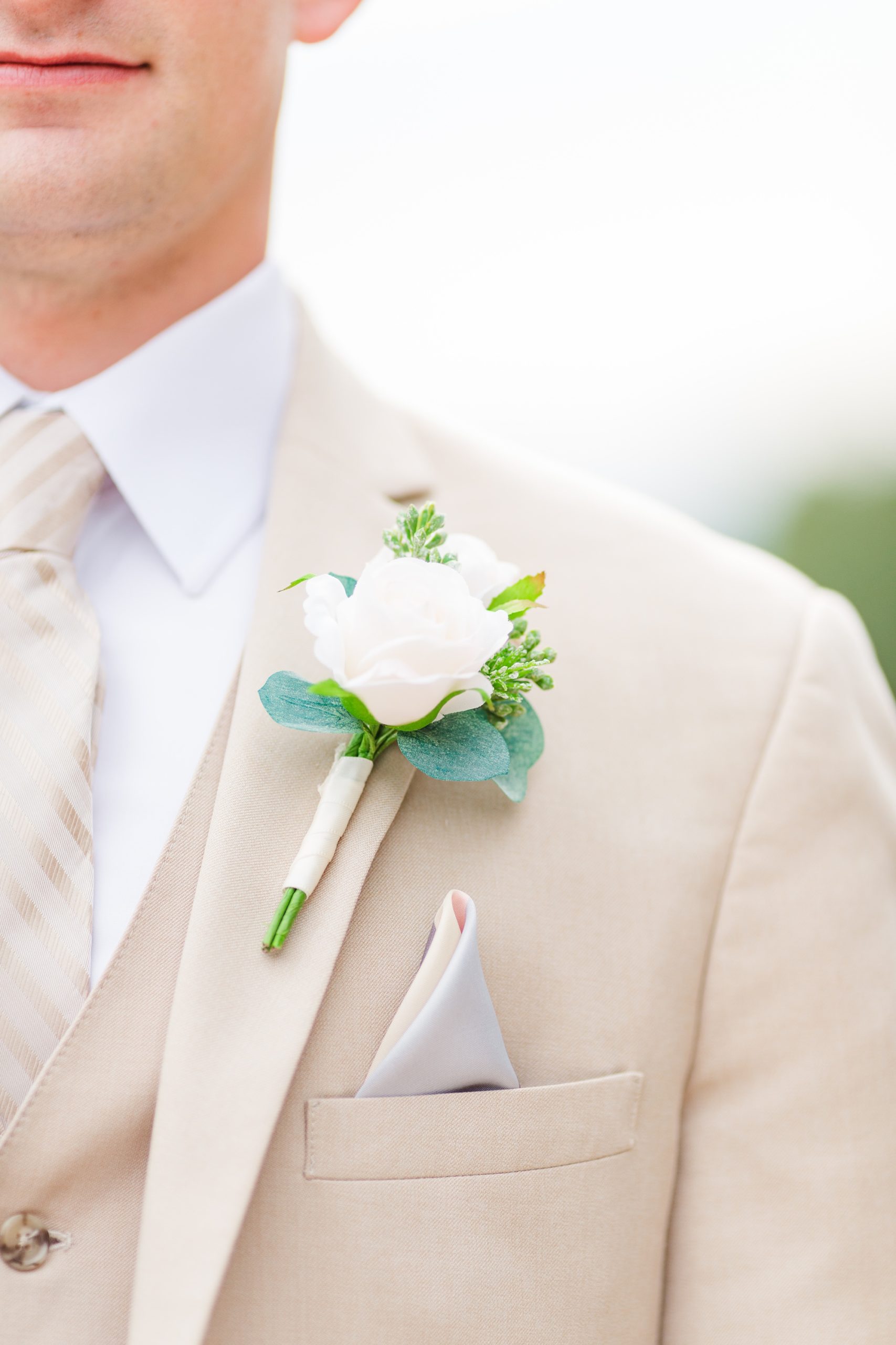 groom's tan suit and white floral boutineere