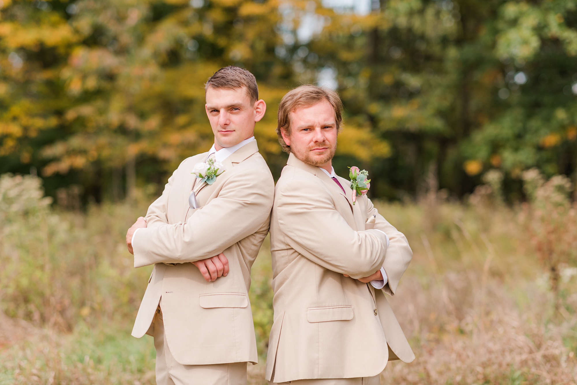 groom and brother pose back to back in tan suits