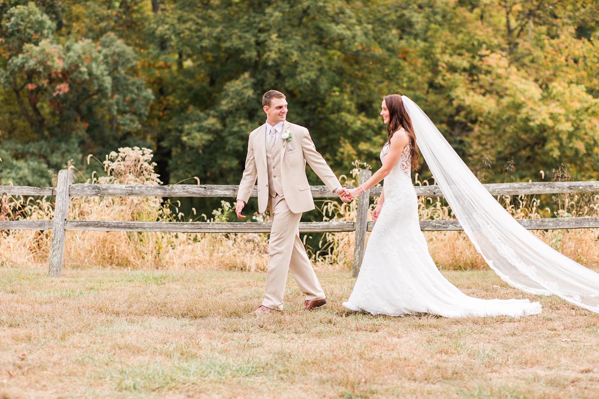 bride and groom walk through backyard