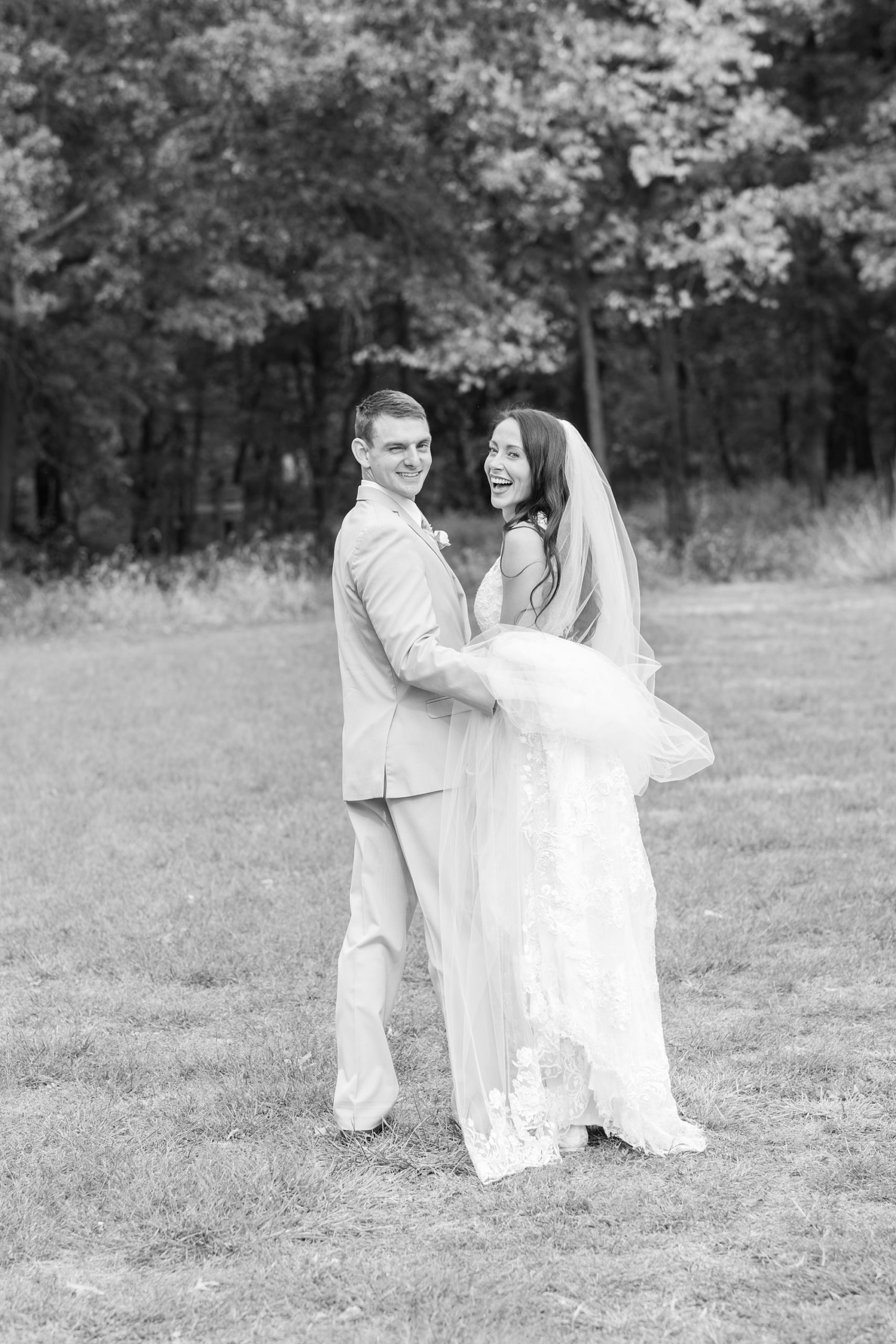bride and groom laugh together during wedding photos
