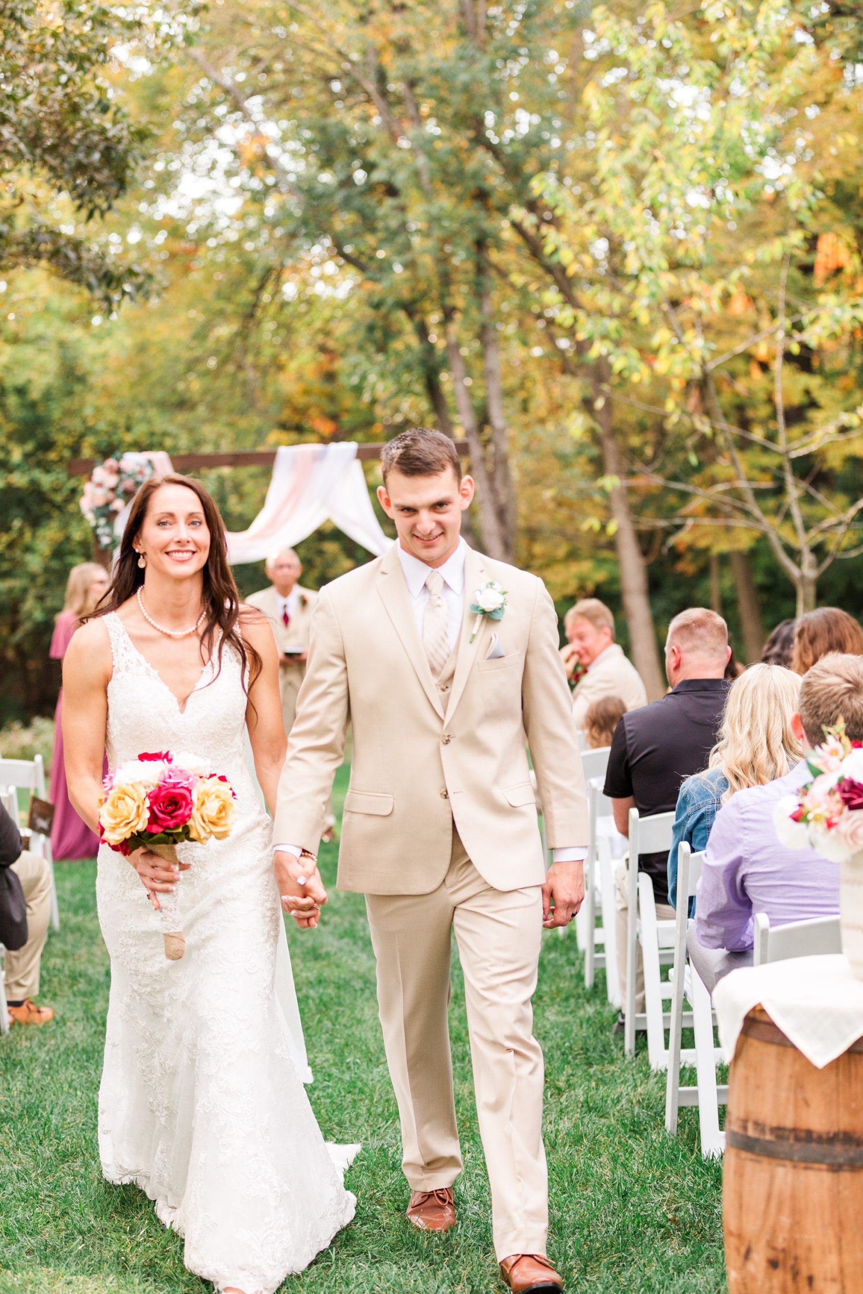 newlyweds walk up aisle during backyard wedding in Godfrey IL