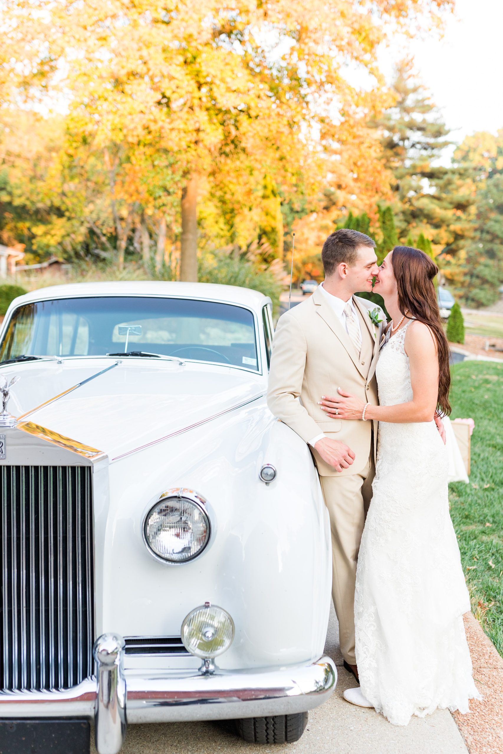 bride and groom kiss by vintage car during backyard wedding in Godfrey IL