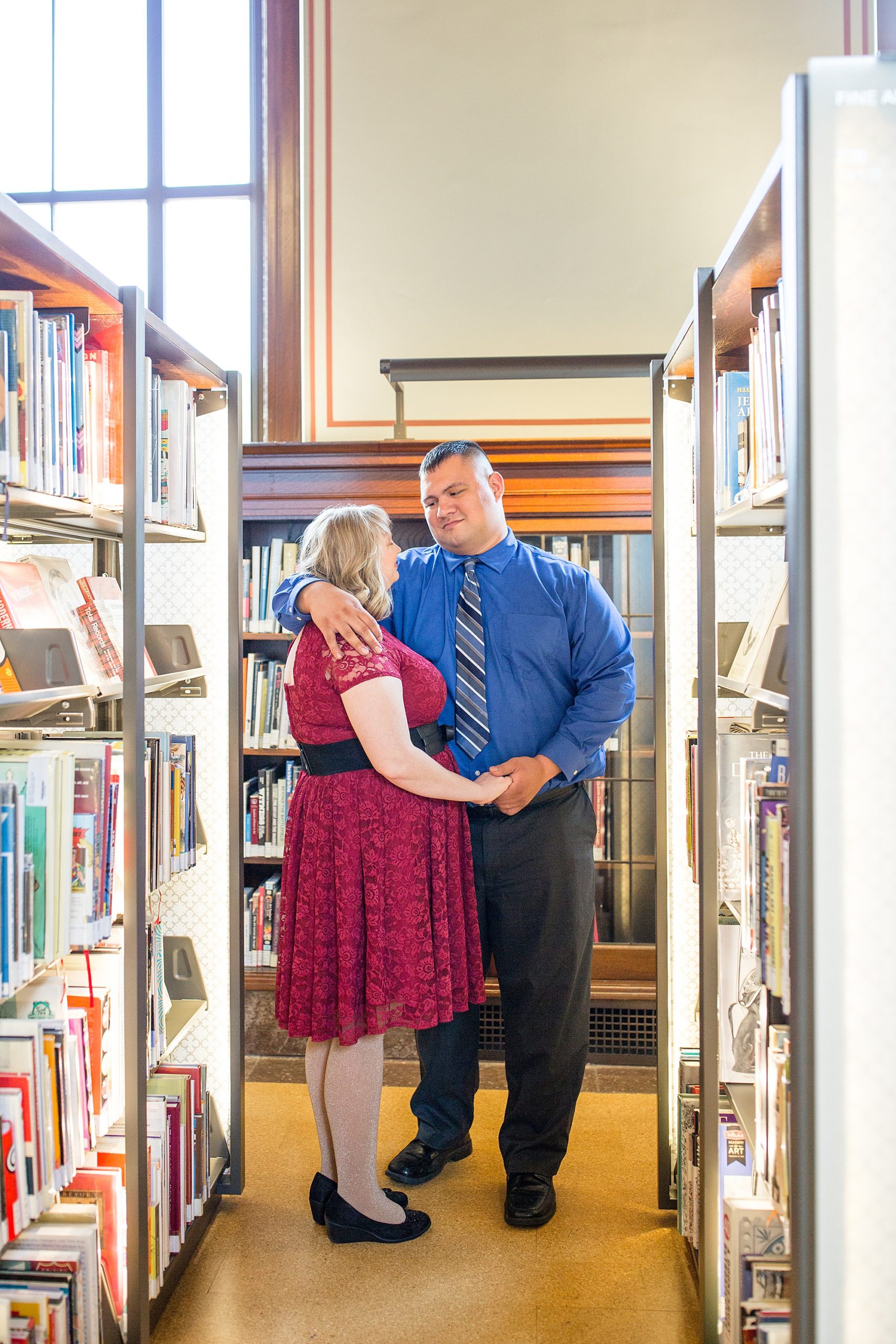 couple hugs in stacks of books at Central Library
