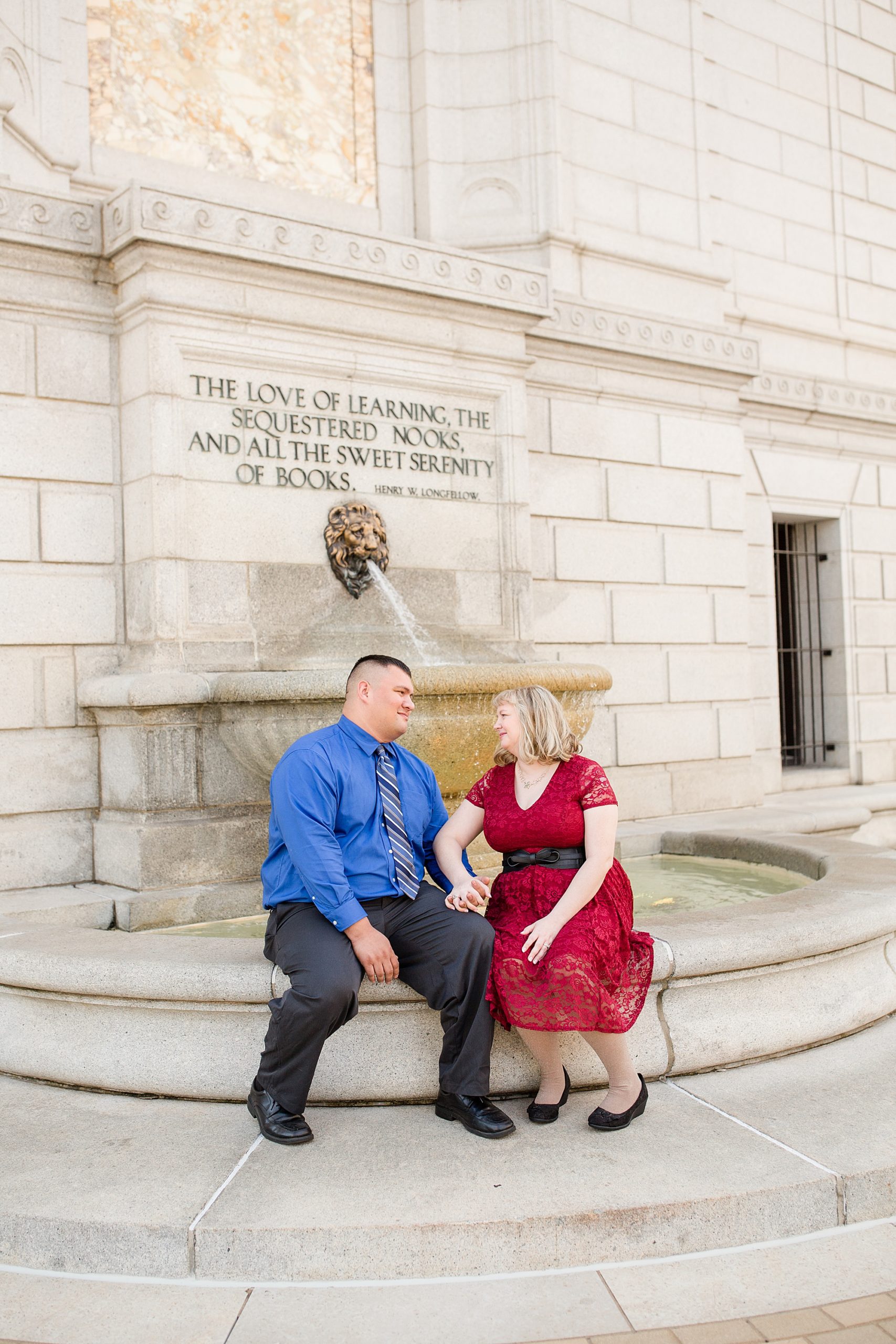 Central Library engagement session with couple sitting on fountain