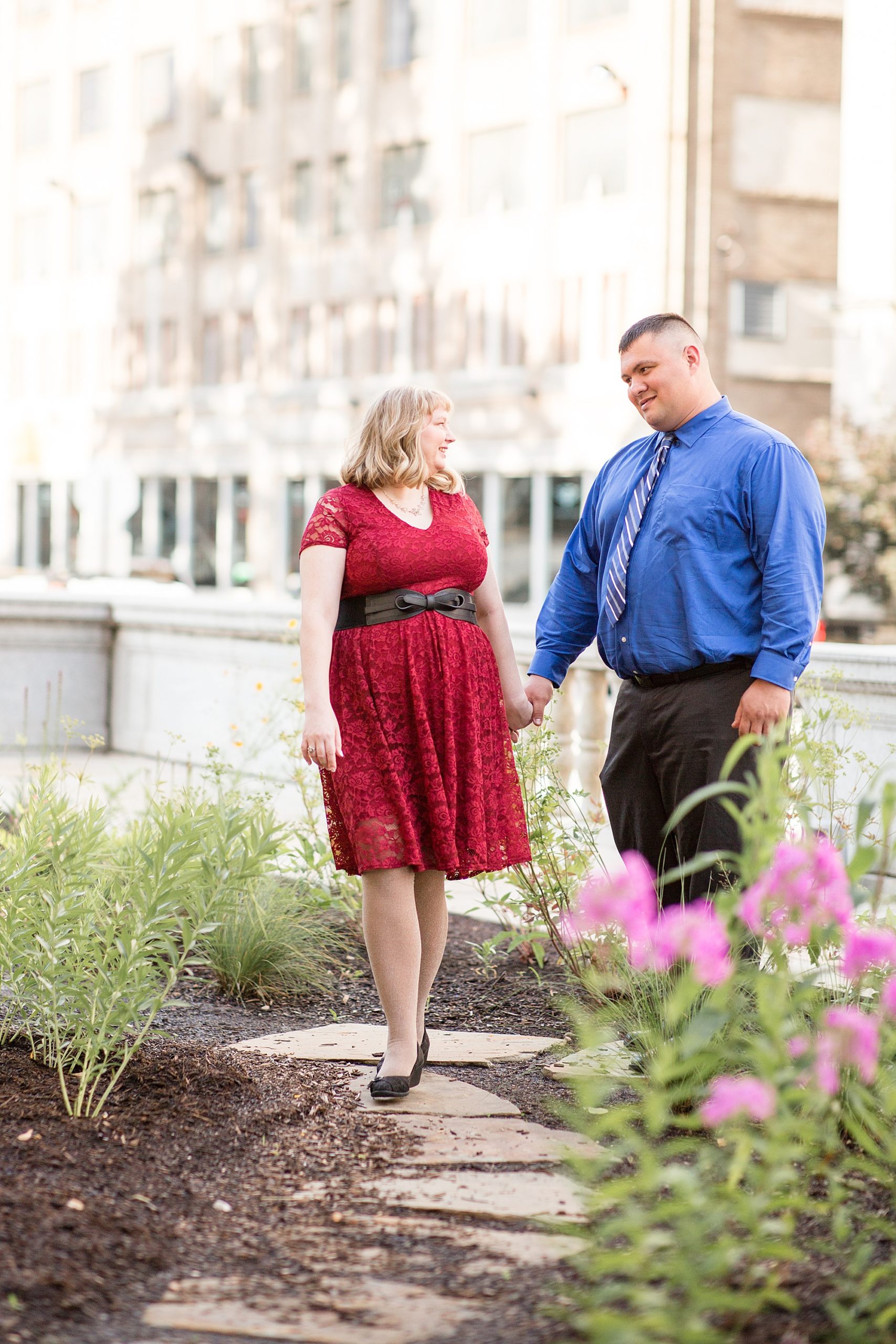 couple holds hands walking through Central Library garden