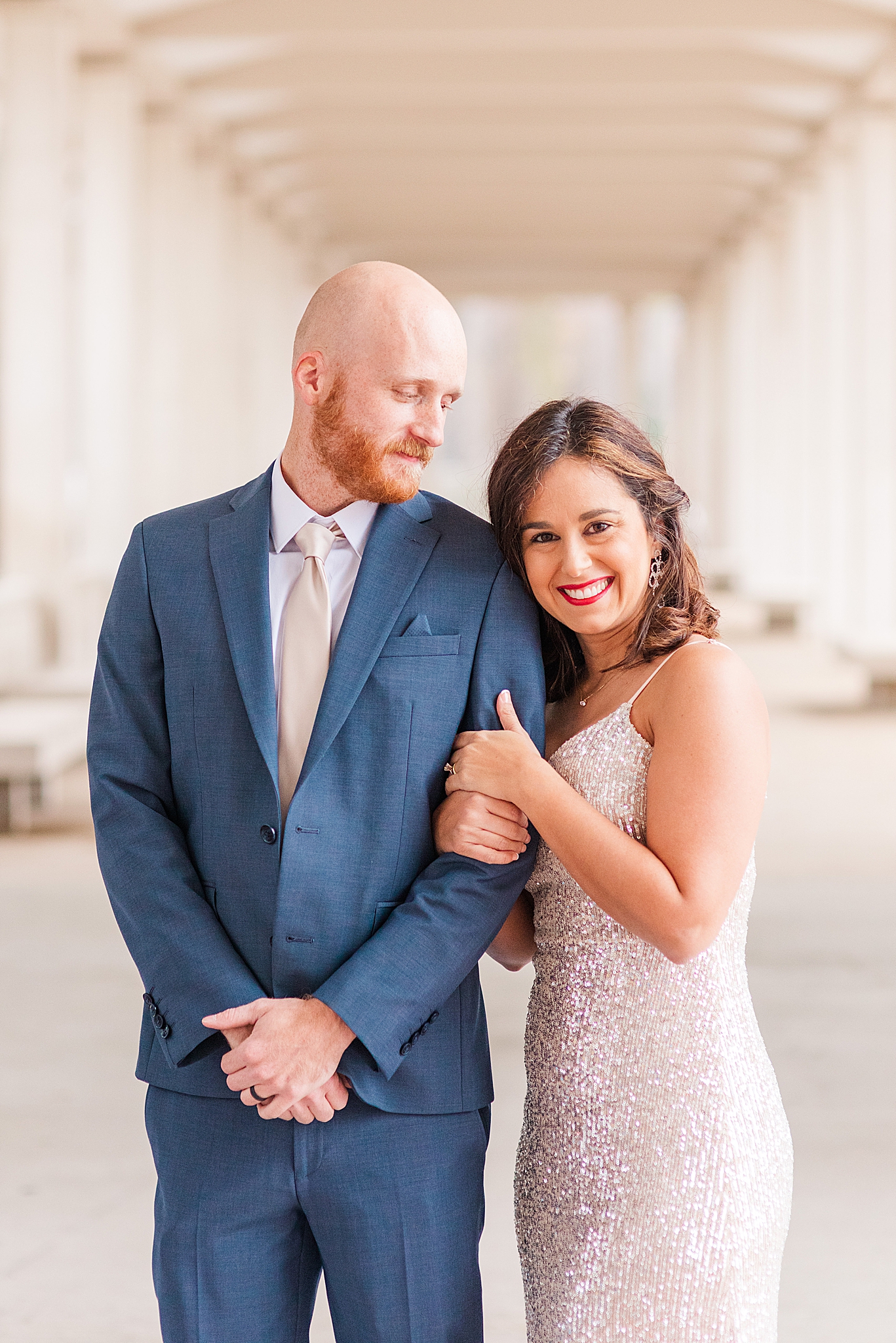 bride leans on groom's arm during winter engagement photos at Forest Park