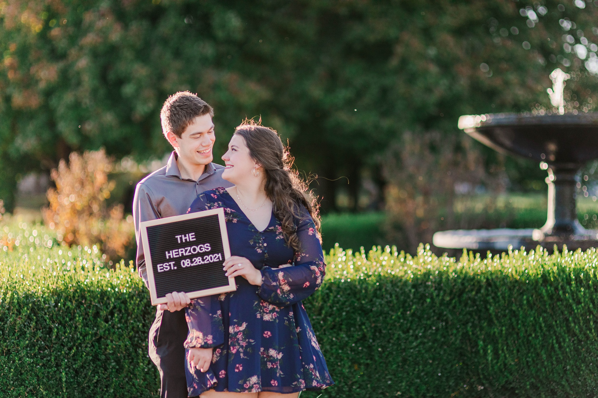 engaged couple holds up letter board