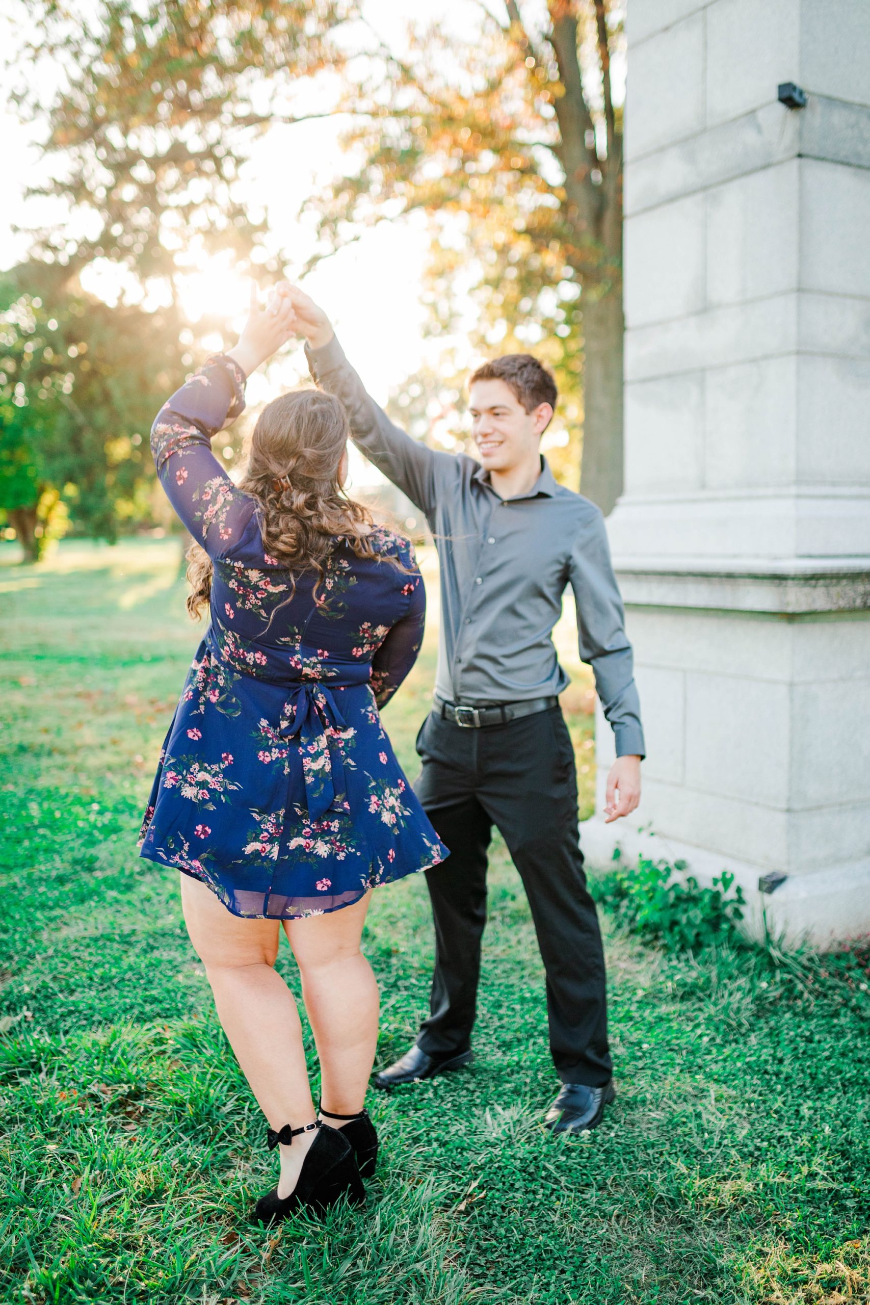 groom twirls bride during engagement session in St. Louis