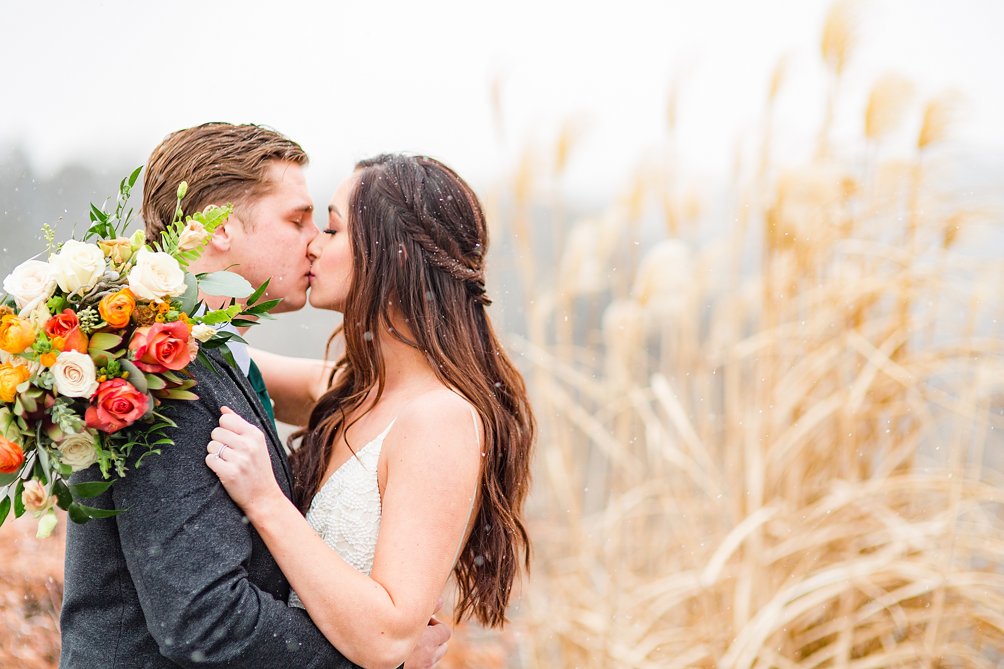 Haue Valley wedding portraits with snow falling as couple kisses