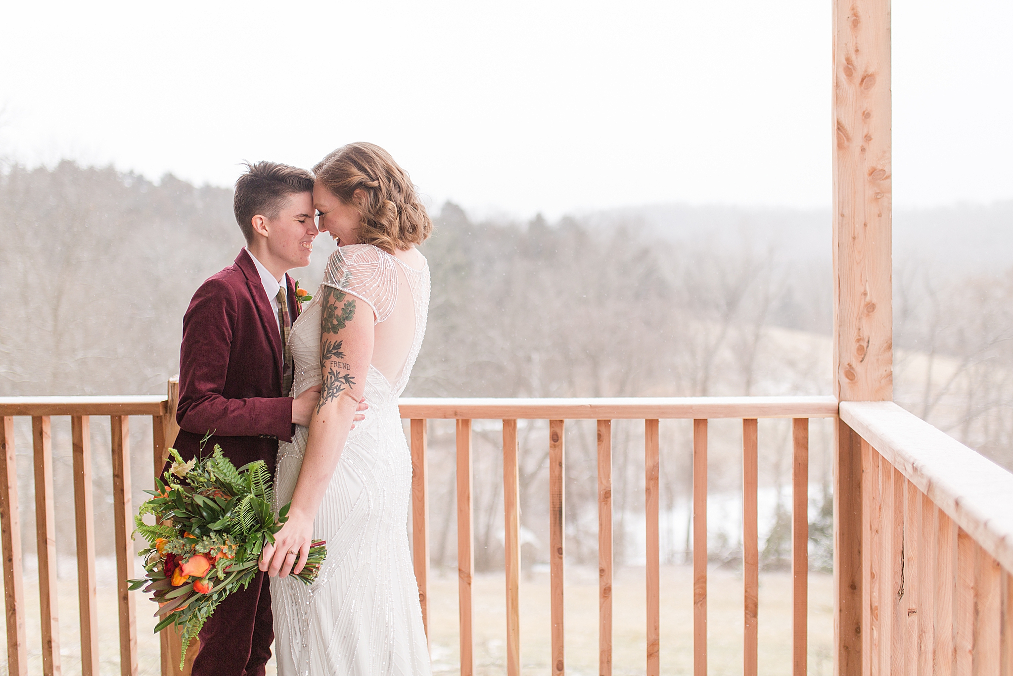 couple poses by wooden railing during portraits at Haue Valley