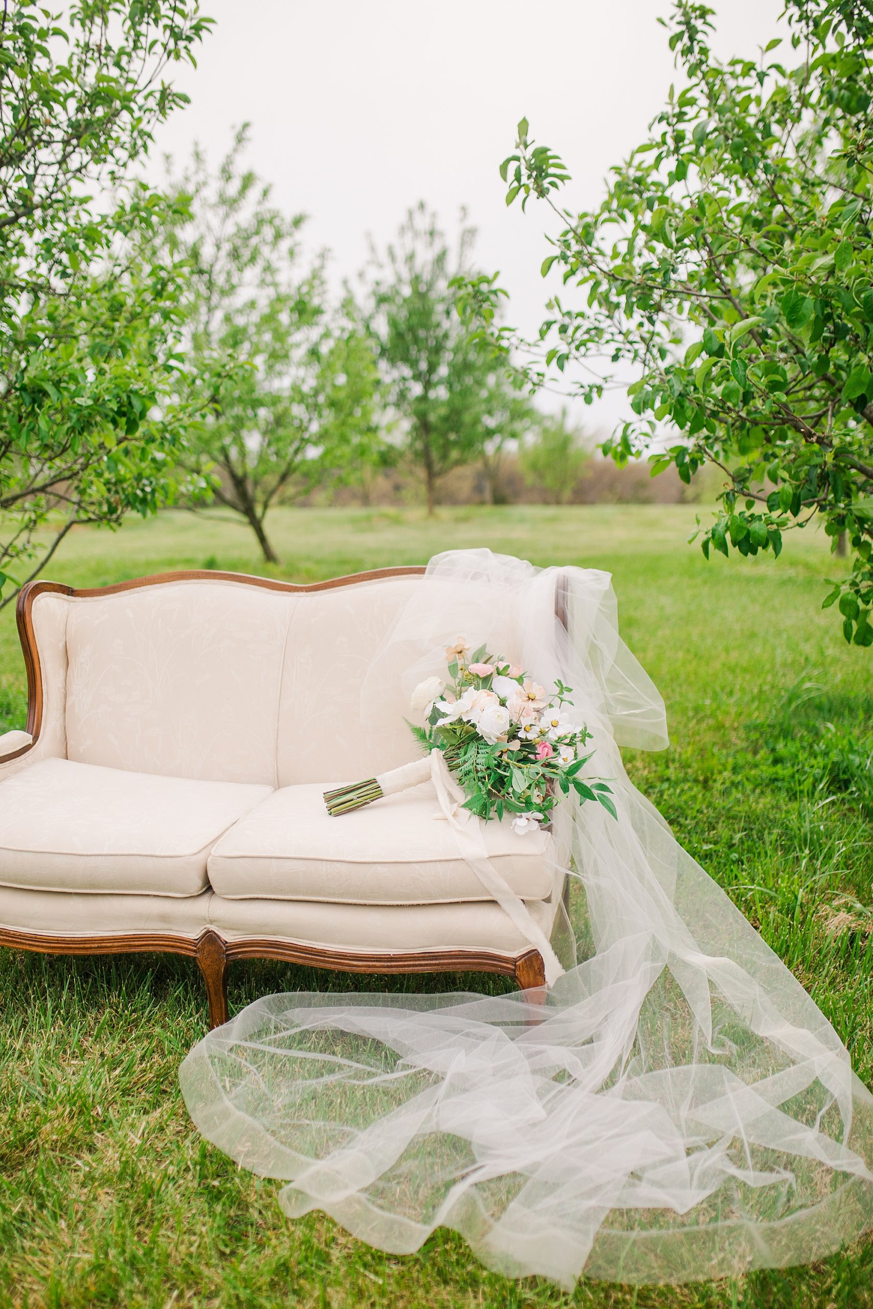 bride's veil lays on couch in orchard at Pierce Century Farm