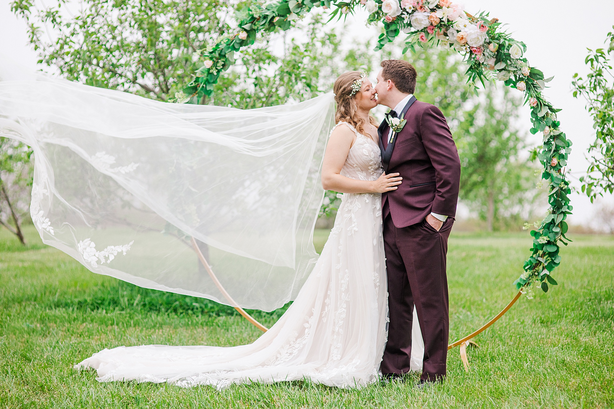 bride and groom kiss by circular arch at Pierce Century Farm