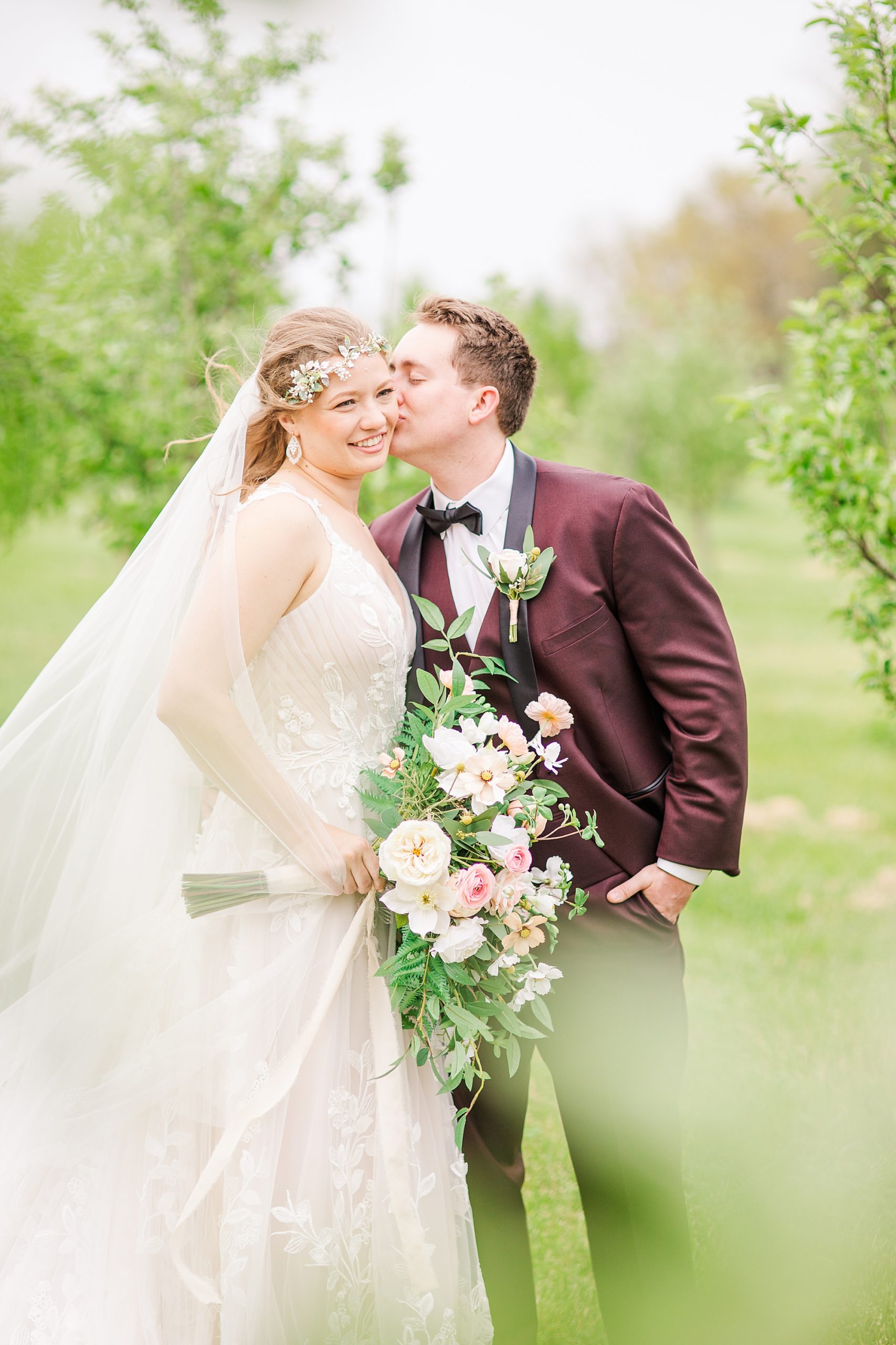 groom kisses bride's cheek during wedding portraits at Pierce Century Farm