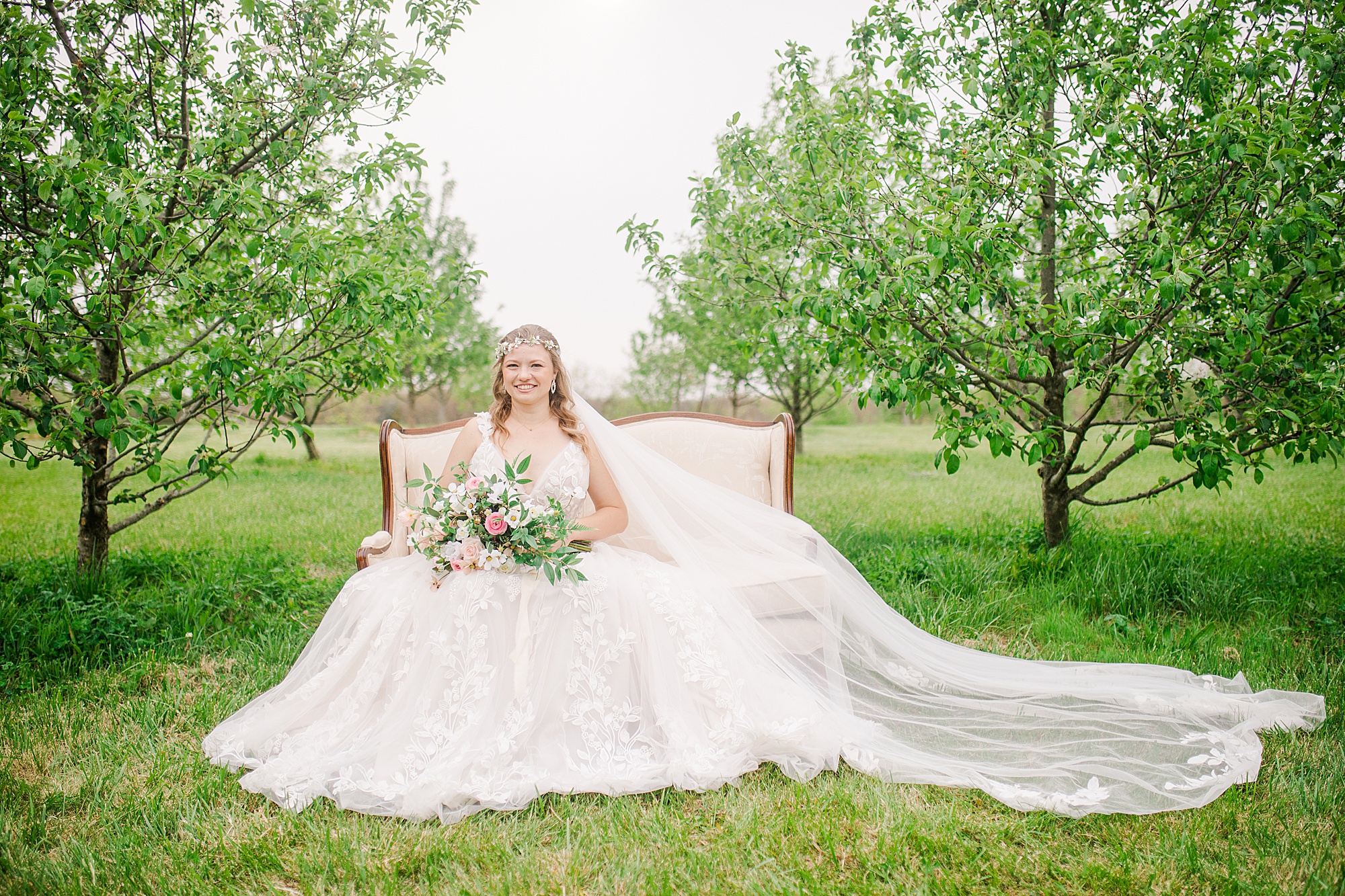 bride sits on couch in orchard at Pierce Century Farm