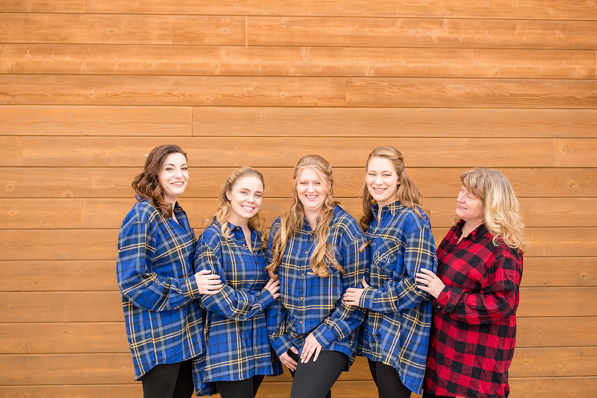 bride and bridesmaids pose in matching flannel shirts