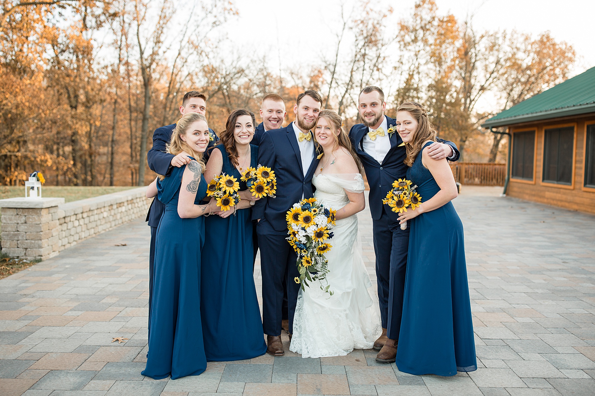 bride and groom hug wedding party in navy suits and gowns