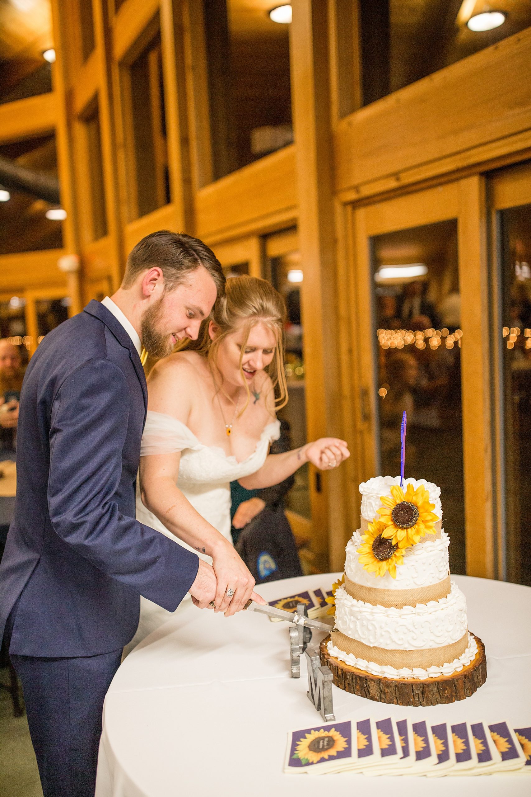 newlyweds cut wedding cake with sunflowers