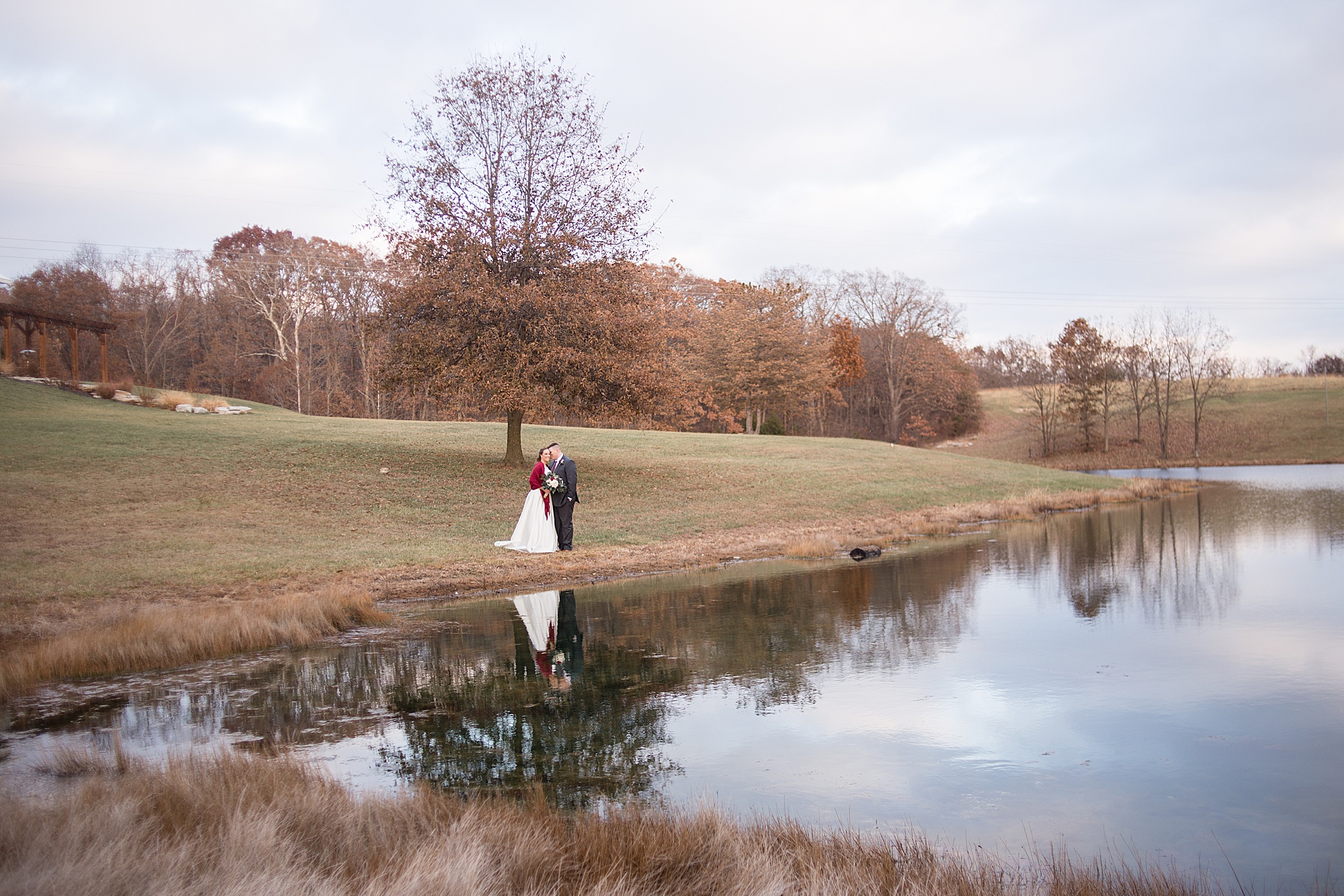 newlyweds walk along lake at Redemption Ranch