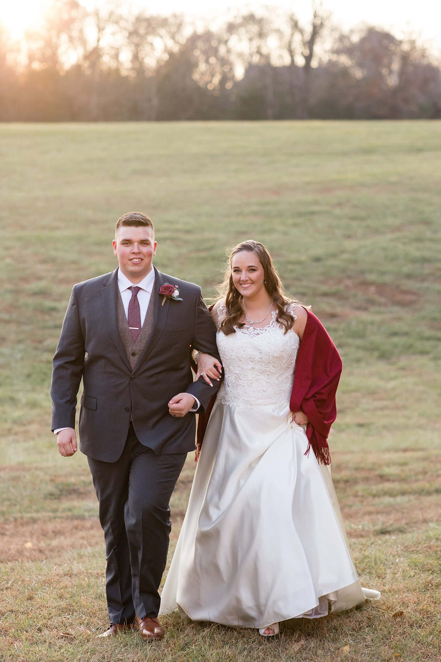 bride and groom walk through field at Redemption Ranch
