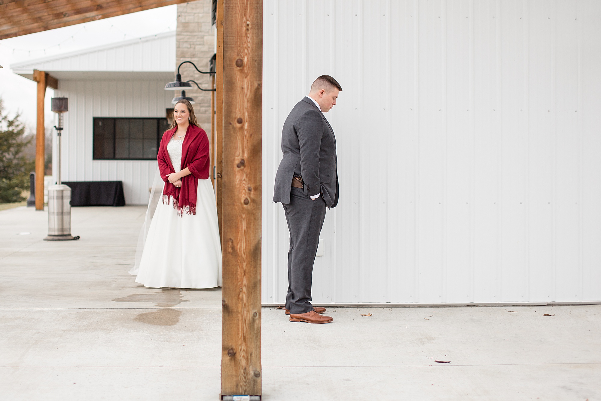 bride and groom stand for first touch around corner at Redemption Ranch