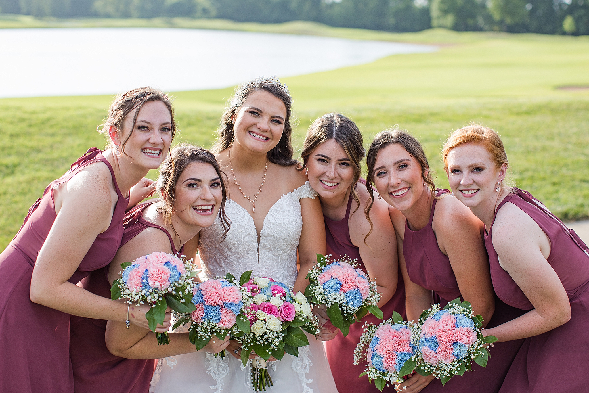 bride poses with bridesmaids in pink gowns at Old Hickory Golf Club