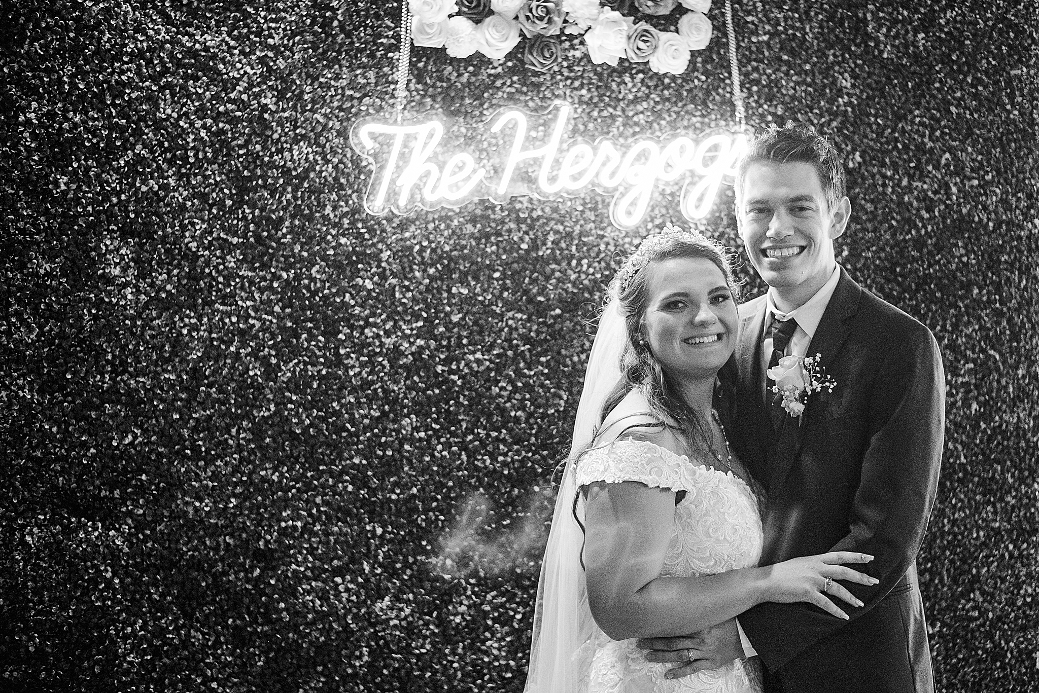 couple poses under neon light at reception