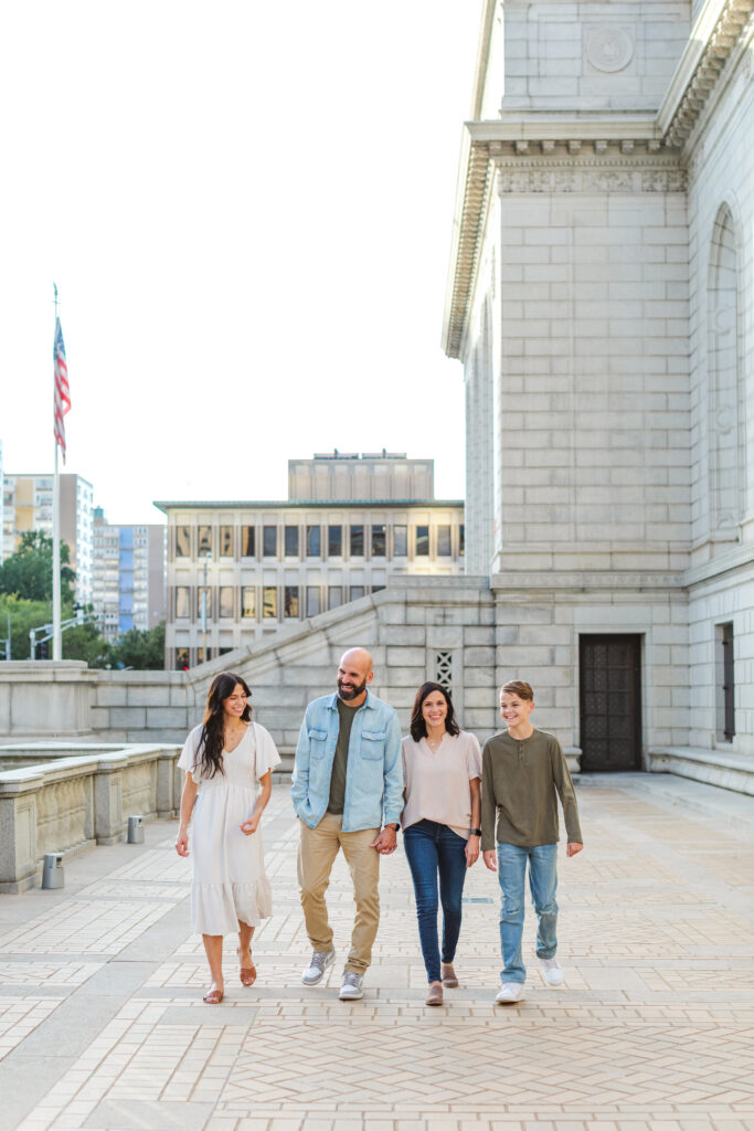 Candid image of a family laughing together outside the St. Louis Public Library during fall mini sessions in St. Louis